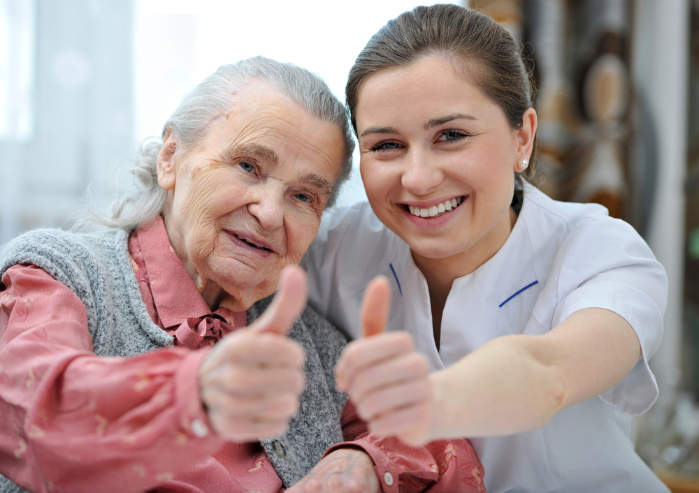 frail elderly with nurse, thumbs up.jpg